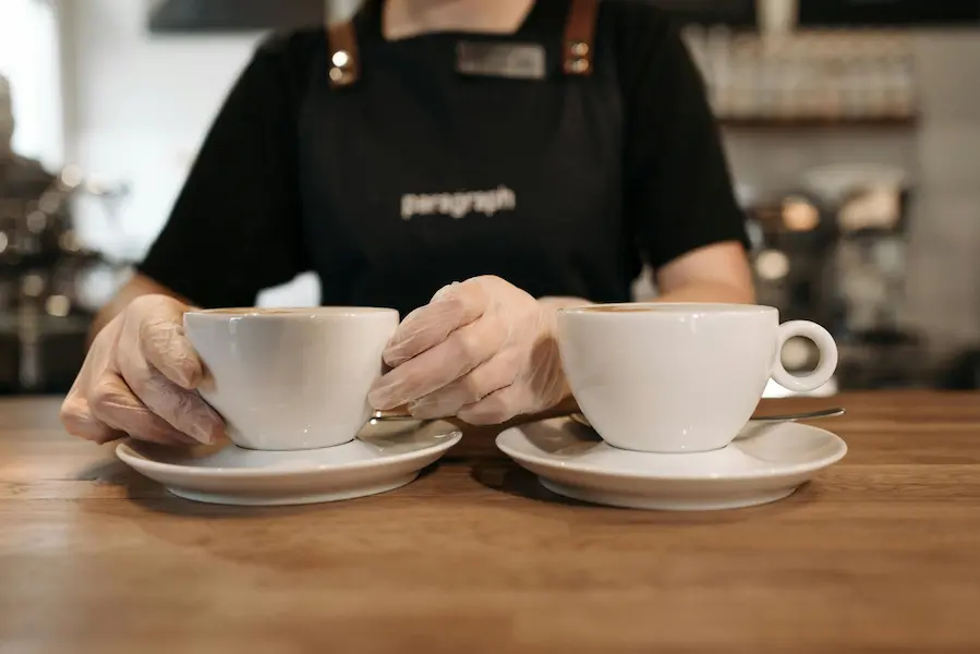 A barista carefully serving coffee